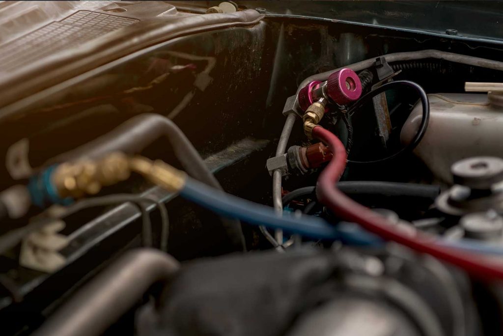 Air technicians are filling the car air conditioning liquid.