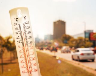 Thermometer in front of an urban scene during heatwave